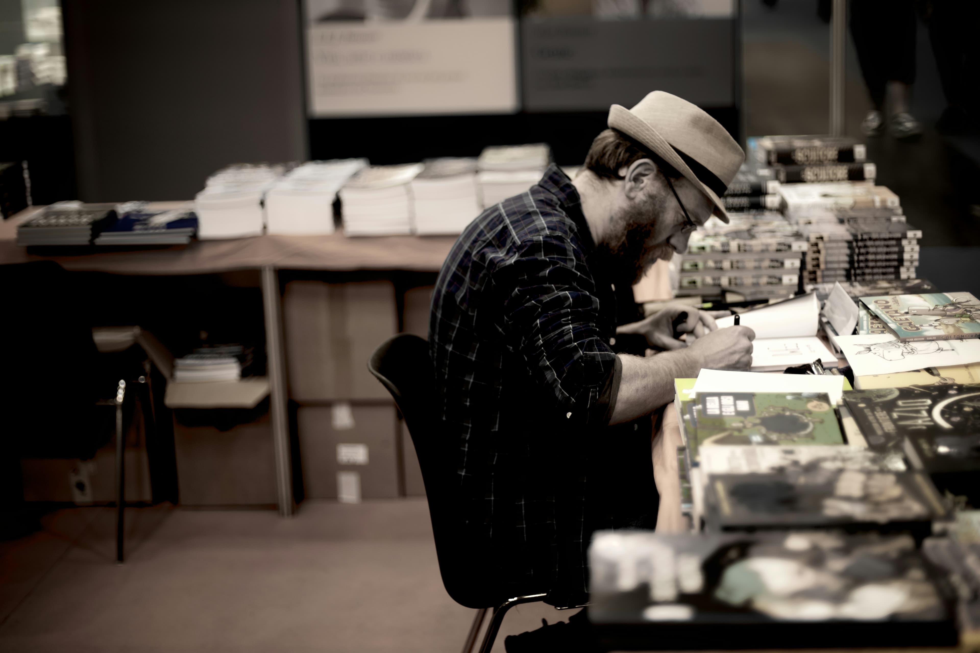 会場で本にサインをする制作者